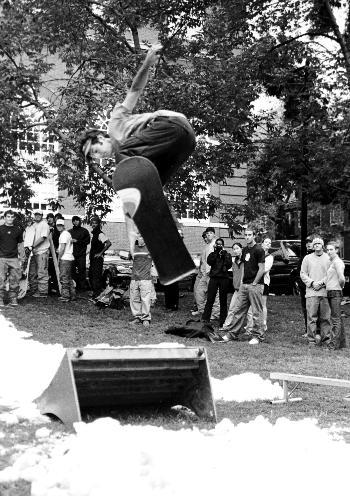 A member of the Harvard University Snowboarding Club gets some air at the clubs annual barbeque on the Mac quad yesterday.