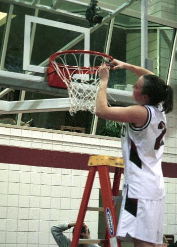 Harvard women's basketball co-captian LAURA J. BARNARD '02 cuts down the net following her team's Ivy title-clinching 77-65 victory over Yale on Friday night.