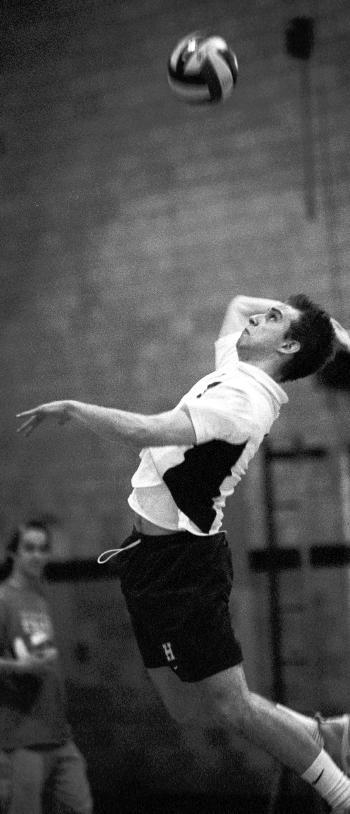 Co-captain MIKE BOOKMAN jumps to serve against Vassar.