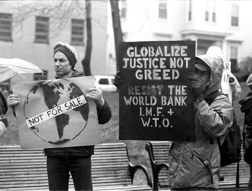 Anti-globalization protesters demonstrate in front of Cambridge City Hall yesterday afternoon. The protest made its way down Mass. Ave. from Harvard Square to Central Square.