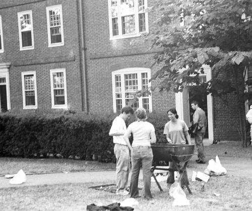 From left to right, SSP proctors BENJAMIN T. SIRACUSA ‘03, ALEXANDRA N. YURKOVIC ‘04 and GITA A. RAO ‘03 clean up a barbeque yesterday in front of Straus Hall, the site of vandalism on Monday.