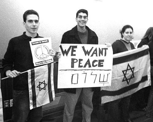 Members of Harvard Students for Israel hold Israeli flags and anti-divestment posters during a panel discussion at the Law School yesterday by five professors who support divestment.  