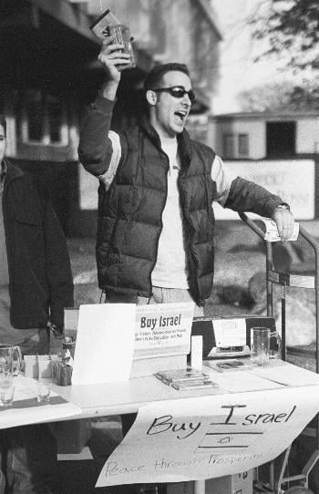 ZACHARY L. BERCU '04 sells candy bars outside the Science Center Friday to raise moeny for Israeli soldiers. The sale was sponsored by Harvard Students for Israel.