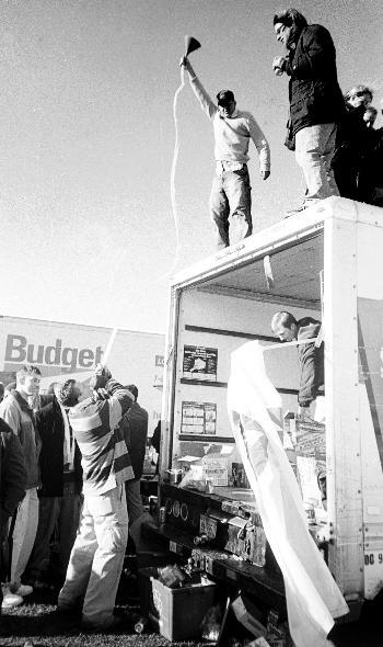 Atop the truck hosting Lowell House’s tailgate, HoCo Treasurer BRIAN J. HAYES  ’03 hoists his funnel high in celebration of the 119th Game Saturday afternoon.