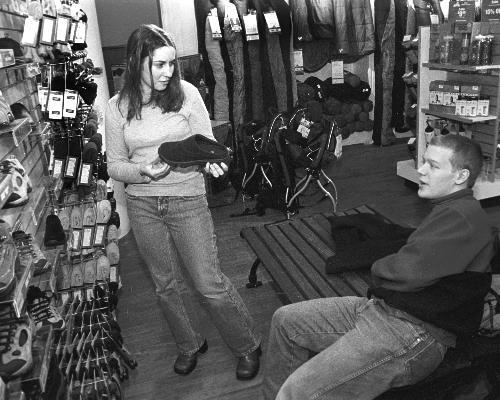 RACHEL A. AICHER ’03 and CHRIS R. LAUMANN ’03 of Eliot House look at footwear in the newly opened Eastern Mountain Sports store on Brattle Street, below HMV.