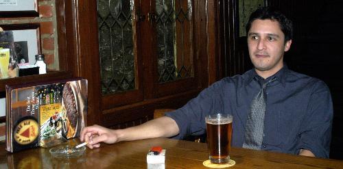 A man enjoys a cigarette and a drink at Pizzeria Uno in Harvard Square. His days of smoking in public may be limited, as the City Council vote on an ordinance that bans  smoking in all restaurants and bars approaches.