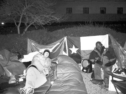 Kennedy School of Government students ADAN D. BRIONES (left), and DARON K. ROBERTS (right) camp out outside the Supreme Court building to get seats for oral arguments of the affirmative action case.