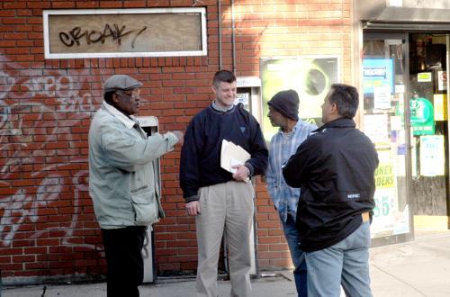 Police officers (second from left and far right) question locals Saturday outside the Pizza Ring that was the scene of the death of Michael Colono early Saturday morning.