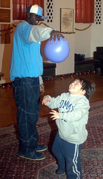 KWAME OWUSU-KESSE entertains JOSE MIGUEL ISCAYAU, son of  Harvard employee Gladys Iscayau, at the Worker Appreciation Day event in Adams House on Saturday.