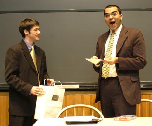 Outgoing Undergraduate Council President Rohit Chopra ’04 excitedly receives a Foxwoods gift certificate from incoming council president Matthew W. Mahan ’05. Chopra fought back tears through much of his last meeting.