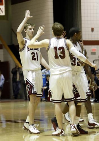 Sophomore forward Matt Stehle (21) high fives junior guard Kevin Rogus after the Crimson's 78-71 win over Yale on Saturday.