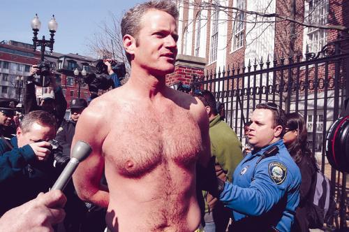 Dan Mathews, vice president of People for the Ethical Treatment of Animals, is arrested in the Square yesterday with five other protestors, including a Harvard student. Chanting “Fur out, love in,” Mathews avoids the media.