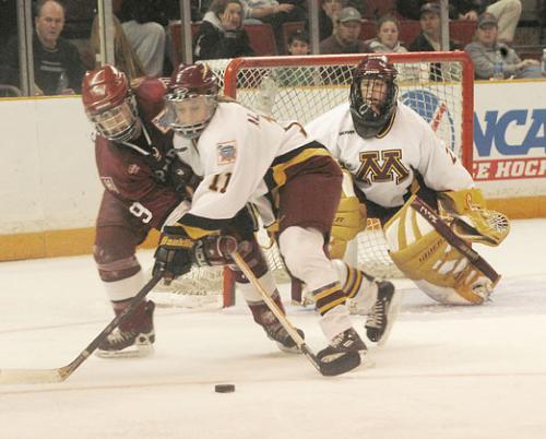 Junior forward Nicole Corriero (9) battles with Minnesota defenseman Ashley Albrecht during last Sunday's NCAA national championship game. Though Corriero and the Crimson fired 33 shots on net, the Golden Gophers shut Harvard down in the third frame.