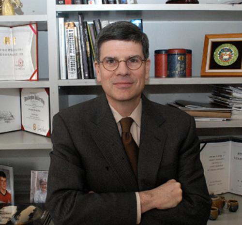 Dean of the Faculty William C. Kirby, who is leading the curricular review, stands in front of his honorary degrees from Chinese universities in his University Hall office.