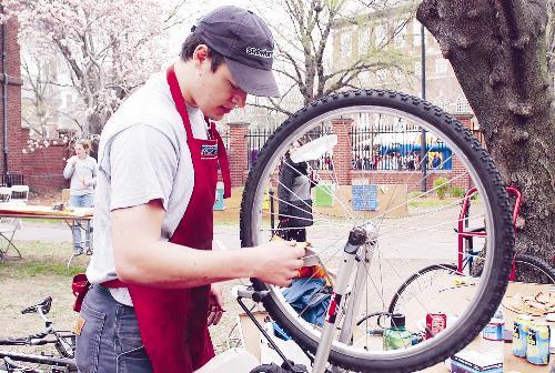 Charlie L. Black ’04 helps fix bicycles in honor of Earth Day yesterday in the Winthrop House courtyard.