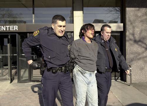 Kenneth Leong, 21, is led from the Science Center after he stormed into an 