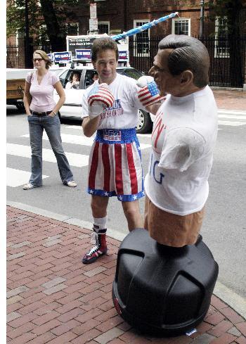 Anti-Bush protestor Leslie Gabriel punches a replica of the president outside Harvard Bookstore on Sunday.