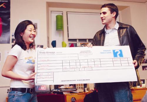 Paul F. Niehaus ’04, right, presents Yiyang Wu ‘07 with a giant airplane ticket in her Eliot House room.  Wu won the prize by playing the Friends Trivia Game on thefacebook.com.