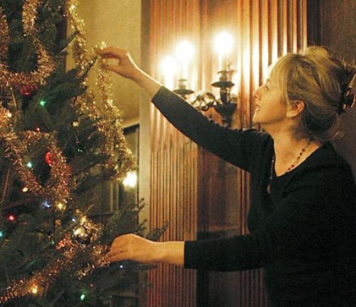 Eliot House Co-Master Anna Bensted places an ornament on the Christmas tree at the House’s annual tree-decorating party yesterday in the dining hall.