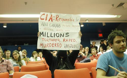 Activist Amee Chew '04 holds a sign yesterday afternoon at an Office of Career Services panel in the Science Center, which featured recruiters from the Central Intelligence Agency and the Department of Homeland Security. 