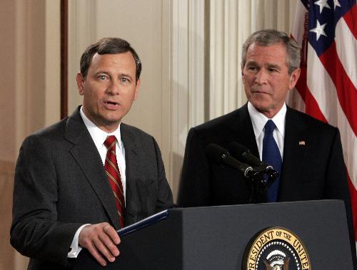 President Bush stands with his nominee for the Supreme Court, John G. Roberts Jr. at the White House tonight in Washington.