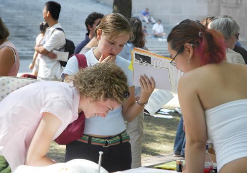Anne Michael Langguth ’09, left, and Caroline C. Pierce ’09, center, talk with Cleo D. Leung ’08 about the Harvard-Radcliffe Orchestra at the Freshman Activities Fair in Tercentenary Theatre on Monday. 