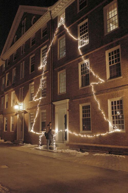 Students enter the illuminated doorway of Hollis Hall North, which is adorned by a Christmas tree made of lights in honor of the coming holiday.
