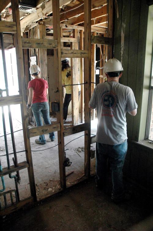 Julian Carmona, a sophomore at UCLA, cuts electrical wiring while Sarah B. Joselow '10 and Jessica C. Coggins '08 perform other repairs on the house. 