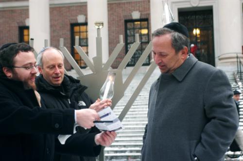 Professor of Government Michael Sandel, former University President Larry Summers, and Rabbi Hirschy Zarchi light the Hanukkah candles with Chabad yesterday in celebration of the first night of the Jewish holiday. 