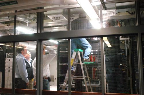 Technicians work to bring the Faculty of Arts and Sciences' IT systems back online in the basement of the Science Center on Friday.