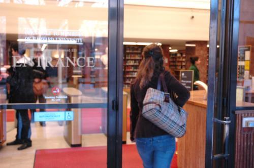 A student walks through the entrance of Lamont Library. Starting March 30, Lamont will no longer allow students without their Harvard ID cards to enter the library. In the aftermath of shootings on college campuses across the country. Lamont has increased
