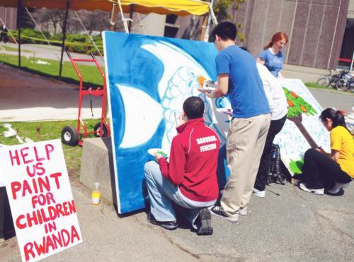 Students paint three large canvases in front of the Science Center yesterday afternoon, which will be used to decorate a children’s hospital in Rwanda. The event is sponsored by the Undergraduate Global Health Forum.