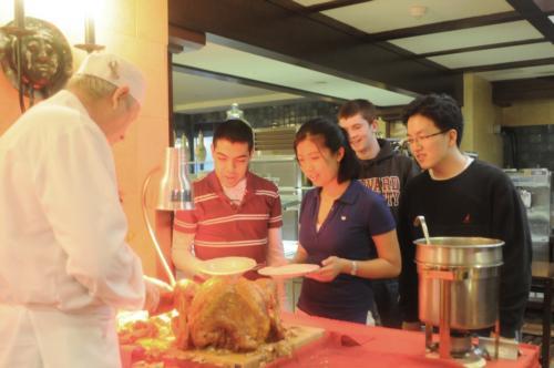 Students staying at Harvard over the break enjoy Thanksgiving dinner served by the dining hall staff of Adams House. Here, long-time Adams House veteran Gary C. Davis carves a turkey.