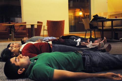 A professional instructor leads students through some elements of Hatha Yoga, which concentrates on physical postures (asanas) and breath control (pranayama) as part of Hinduism Awareness Week.