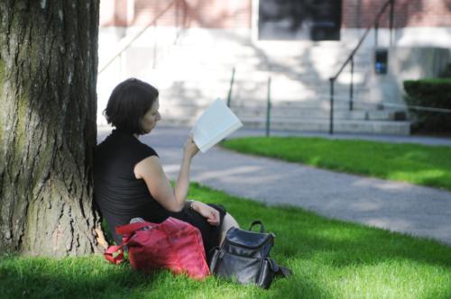 A woman reads in the shade outside Emerson Hall yesterday afternoon.