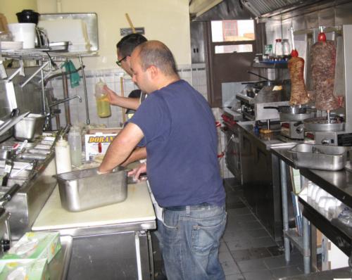 Falafel Corner owner Ahmed H. Naguib and another cook prepare food in the kitchen of the new eatery.