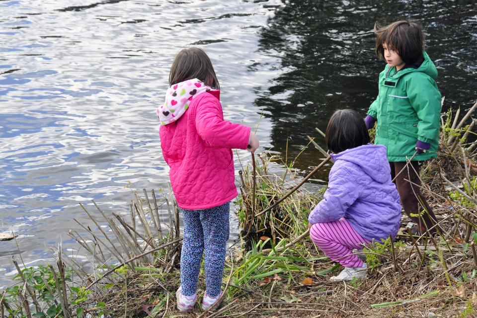 Children play games by the Charles River while their families watch the boat races on Saturday afternoon.