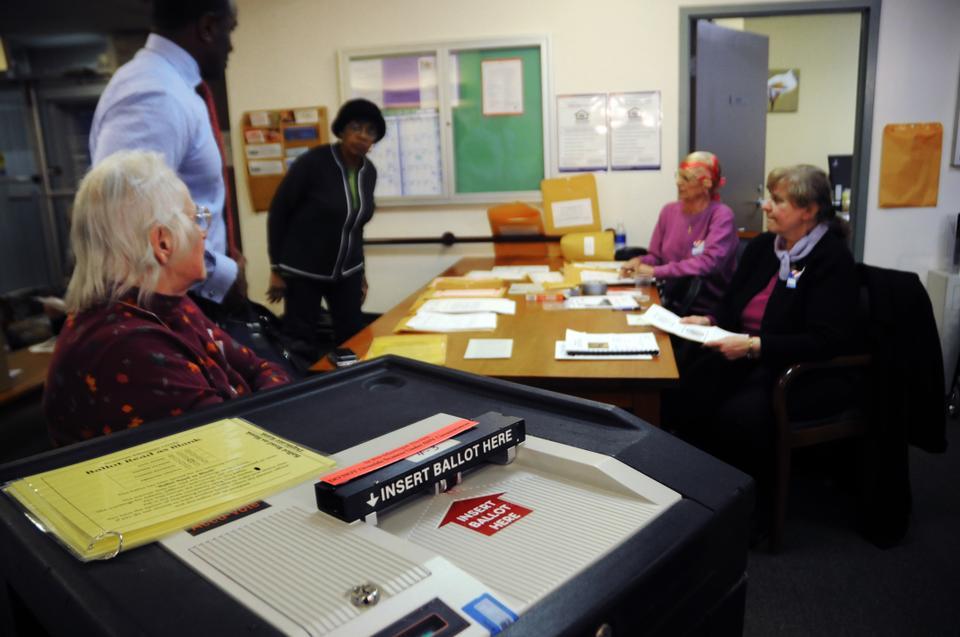 Voting staff waits at 2 Mt. Auburn St., otherwise known as Ward 4 Precinct 3, as voters cast their votes for mayoral and school board elections yesterday.