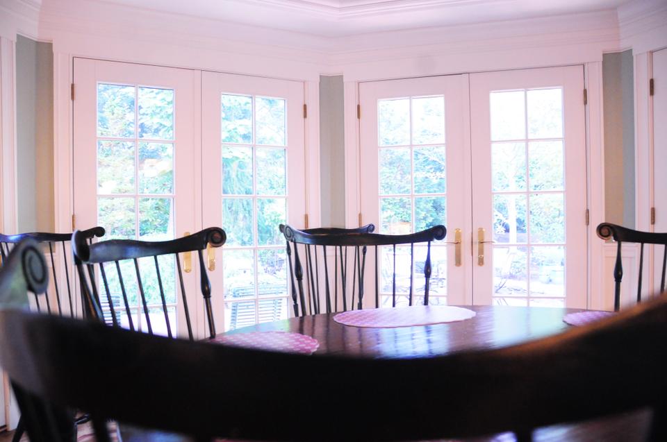The dining room is conveniently right next to the large kitchen, illuminated by sunlight from the wall of paneled glass doors.