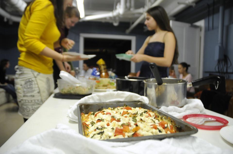 Students take part in a vegan/vegetarian Thanksgiving potluck in the Lowell House Grill yesterday organized by The Harvard College Vegetarian Society. The event featured Asian fried rice, eggplant stew, roasted eggplant, and candied pumpkins, among other foods.