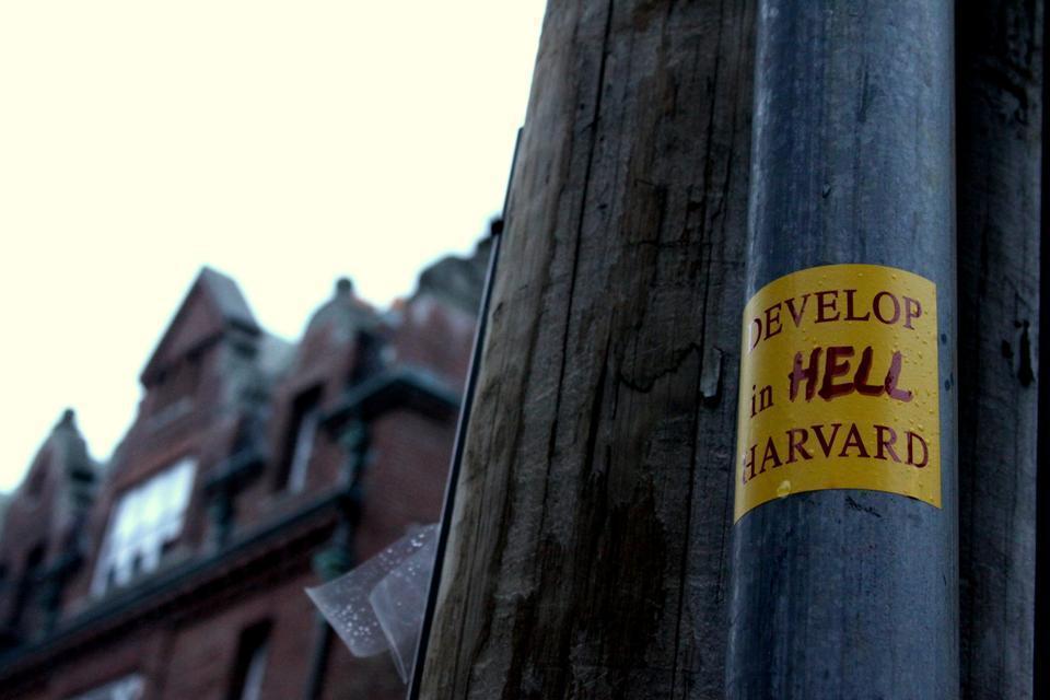Harvard’s ambitious and stalled development in neighboring Allston has led to conflicts with local residents, like this series of “Develop in Hell Harvard” stickers that have shown up around campus and in Allston. This one was placed on an electrical pole on Plympton Street.