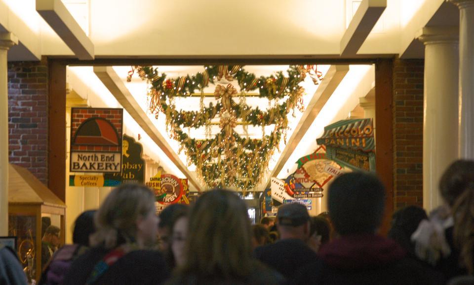 Visitors crowd Quincy Market and savor the eclectic food and newly strung holiday decorations that filled the rafters of the Boston landmark.