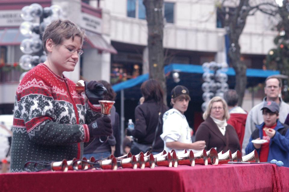 A handbell ringer entertains with holiday songs such as “Dance of the Sugar Plum Fairy” at an annual holiday festival at Quincy Market and Fanueil Hall.