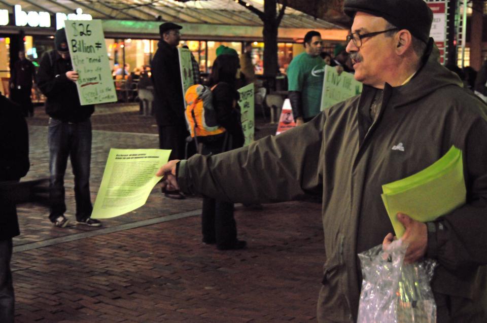 Harvard workers and their supporters rally outside of the Holyoke Center yesterday evening. Rally participants chanted slogans and held signs that urged Harvard to rehire laid-off workers.