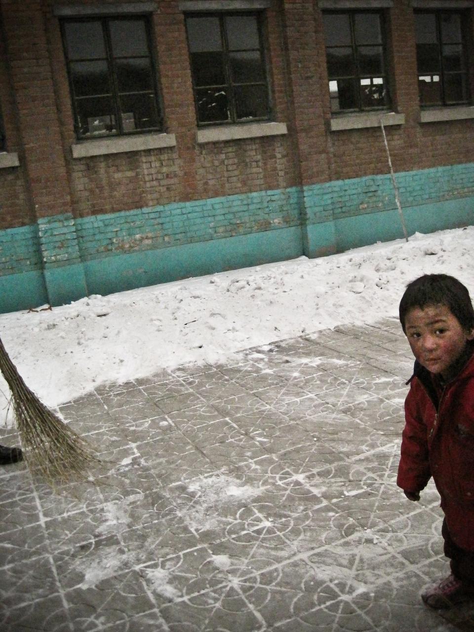 A homeless child walks by the Guang Ai school in the outskirts of Beijing, China.