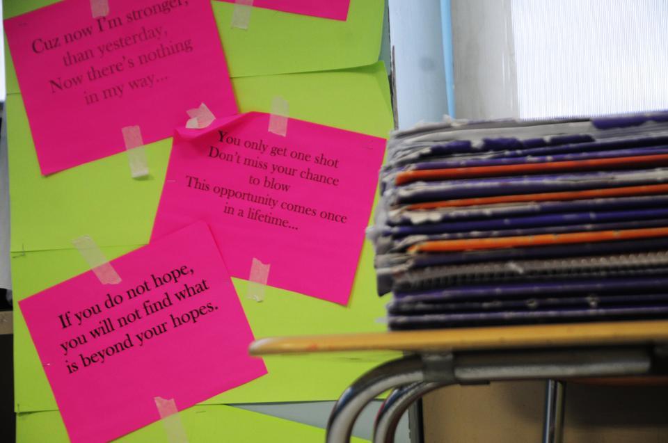 Motivational slogans and inspirational quotes surround every corner of the classroom, often printed on bright pink paper like these.