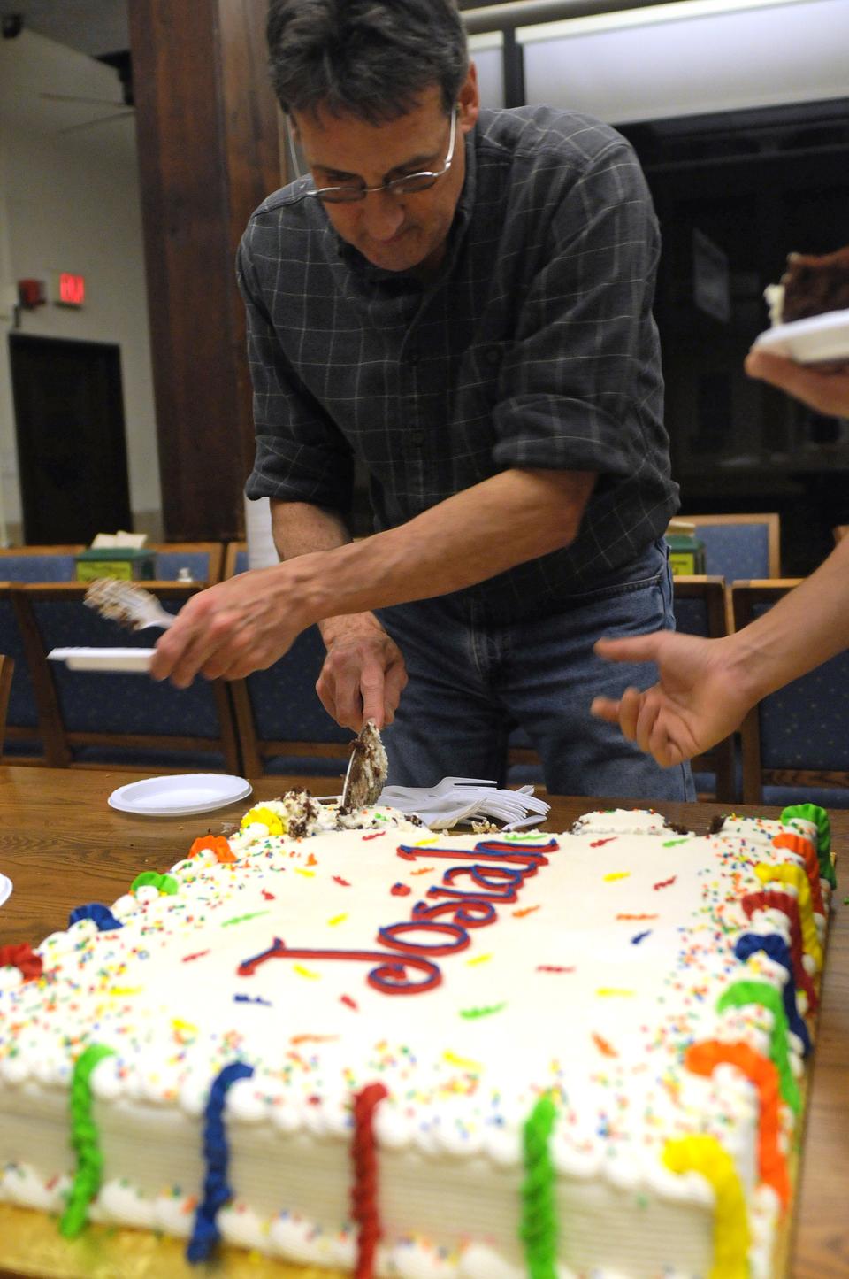 Quincy House Administrator Larry Peterson cuts a birthday cake for Josiah Quincy during Quincy House's community dinner yesterday.
