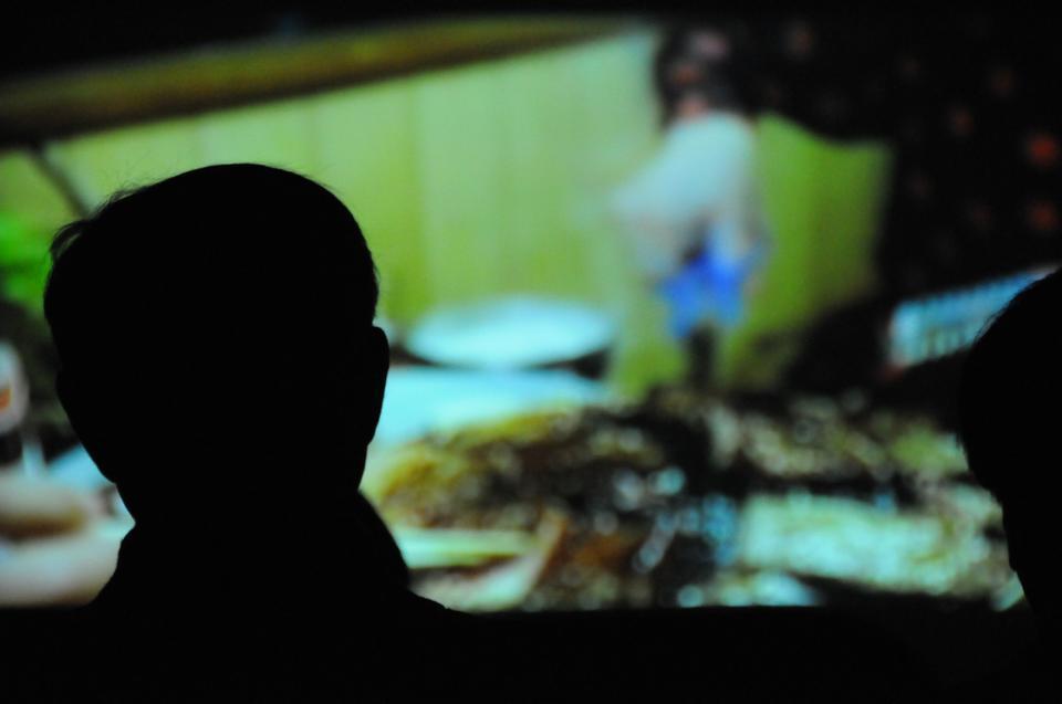 An attendee at the Food at Twenty-Four Frames Per Second film festival’s first screening, which was held at the Adams Pool Theatre, watches the film “Tampopo” by writer-director Juzo Itami. “Tampopo” explores the connection
between food and sexuality through its depiction of a restaurant owner set on making the perfect ramen noodle. Ramen noodles were served after the viewing to supplement the images of food onscreen.
