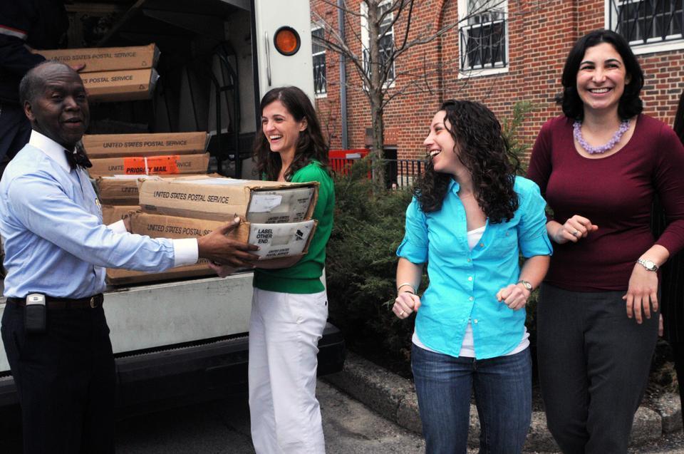 Admissions officers smile and cheer as the last box of decision letters is loaded onto the truck to be sent to students around the world. 
