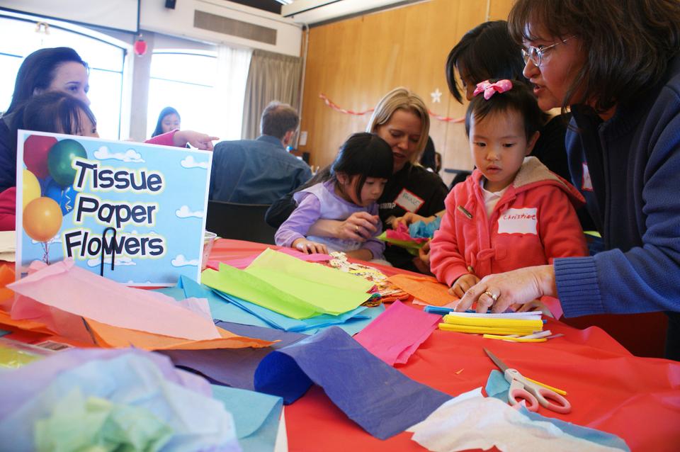 At this weekend's Chinacare Carnival, Anne and Lea select tissue paper for their flower, while Lisa and Christine eye the pipecleaners.
